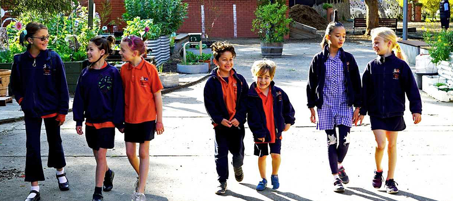 7 children walking and smiling from Richmond West Primary School