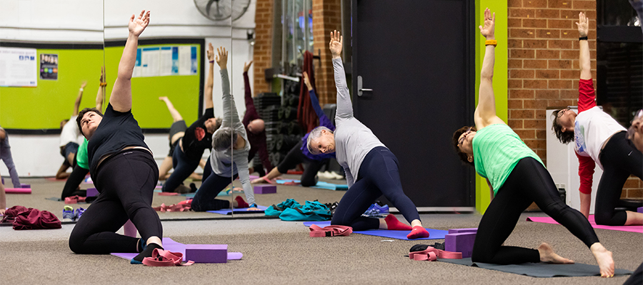 A group of people participating in a Yoga class at Collingwood Leisure Centre