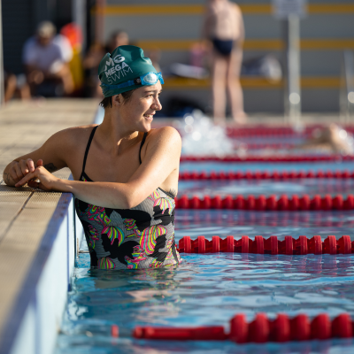 Female swimmer with MS Mega Swim logo on swimming cap in Fitzroy Swimming Pool