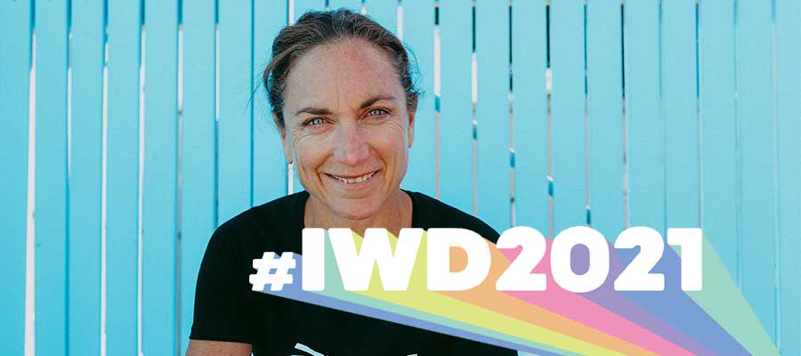 Emma Carney who is a Triathlete smiling with text #IWD2021 overlaying the image