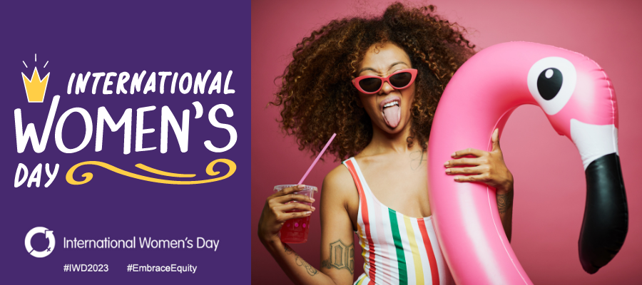Woman with a swan blow up pool toy, a drink and pink sunnies smiling. Written text on image states International Women's Day