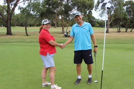 Women and man shaking hands on a golf course