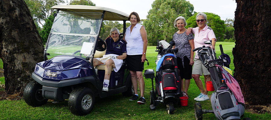 A group of women from Burnley Women's Golf Club standing on the golf course with their clubs and smiling
