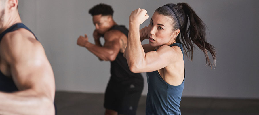 A woman and man in a Body Combat group exercise class