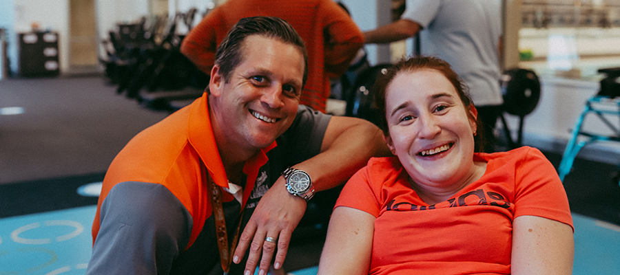 A woman participating in a Cerebral Palsy Program at Yarra Leisure with a male Gym Instructor next to her and both smiling