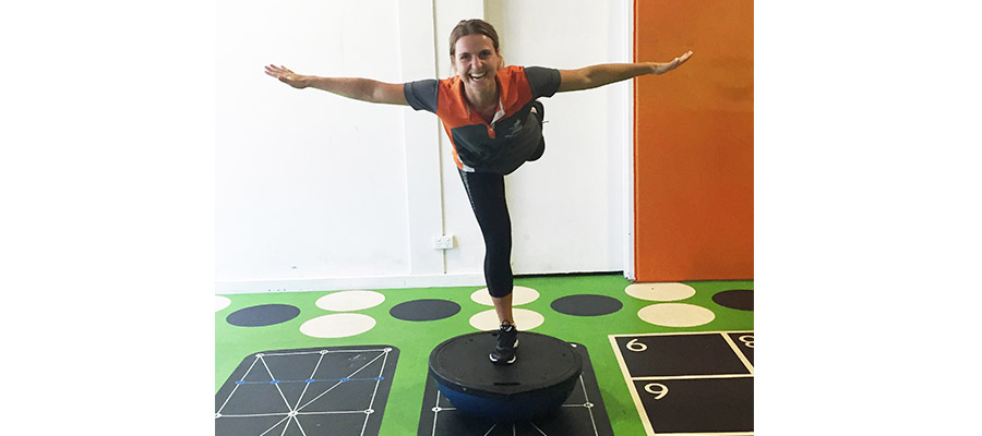 Woman balancing on one leg on an upside down BOSU ball