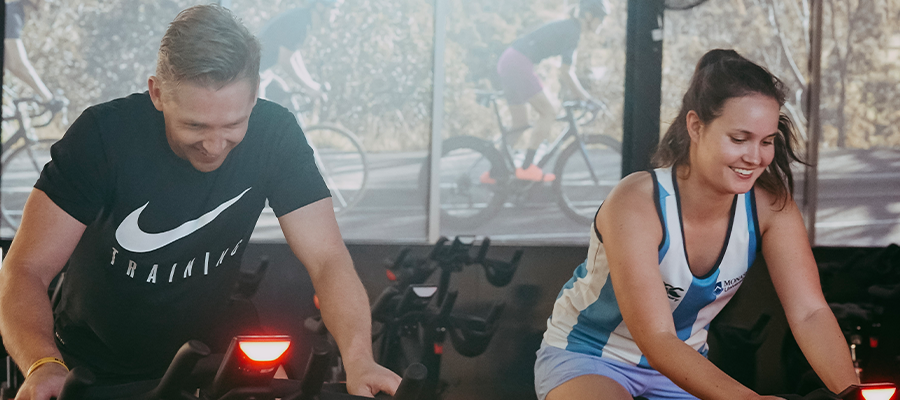 A man and a woman riding an ic7 spin bike at Richmond Recreation Centre spin studio