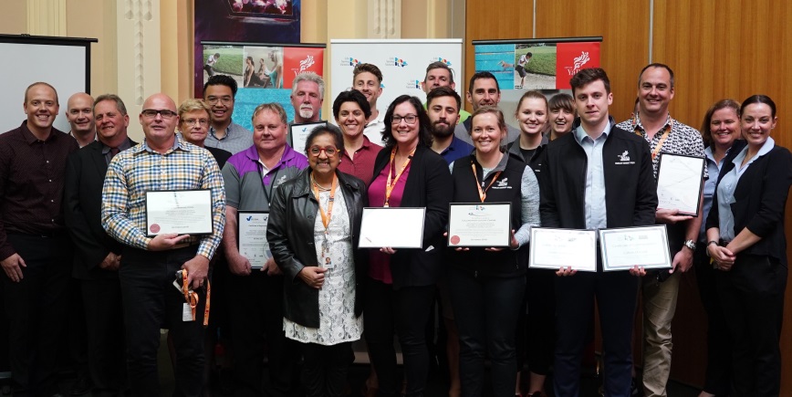 A group of staff holding awards
