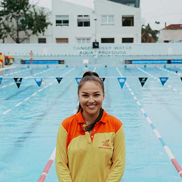 Yarra Leisure lifeguard standing in front of the Fitzroy Swimming Pool 
