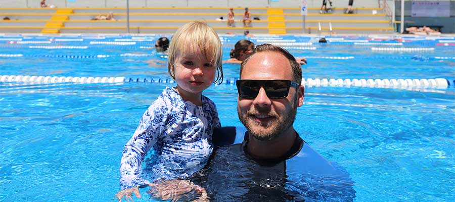 A dad and his daughter in Fitzroy Pool smiling