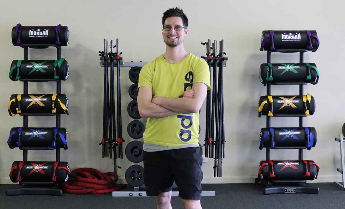 Gym Instructor Adam standing with arms crossed and smiling