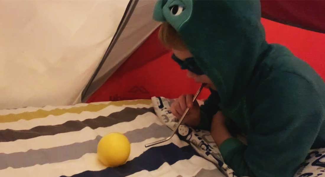 Swimming Instructor Anna's young son blowing bubbles in his cubby house at home