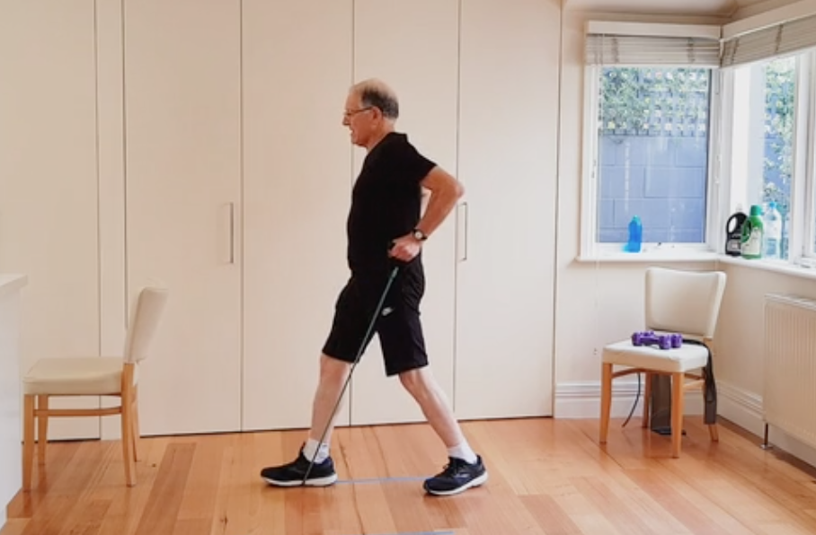 Jeff doing a lunge and pull with a resistance band at home