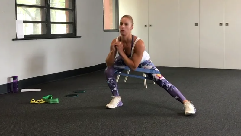 Yarra Leisure gym instructor doing a side lunge with a band