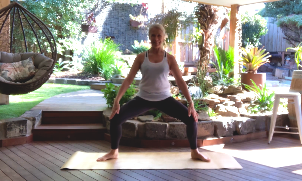 Gym Instructor Lisa holding a wide squat in her garden