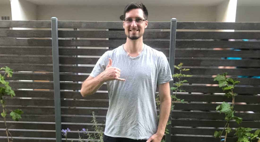 Gym Instructor Adam in his backyard with his thumb up and smiling