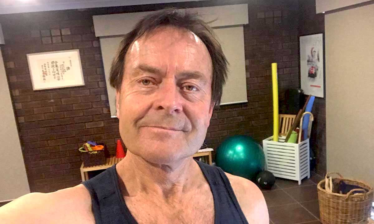 Gym Instructor Bill taking a selfie and smiling in his house wearing his active wear