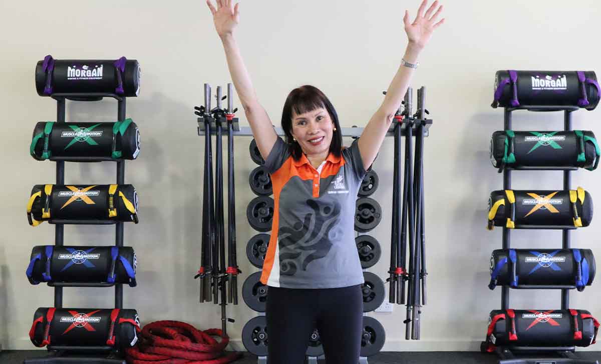 Gym Instructor Sharon with arms up smiling