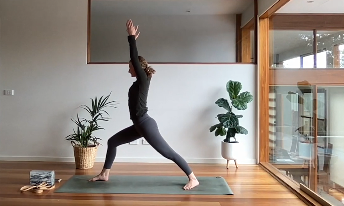 Yarra Leisure instructor Caragh performing a yoga move on her mat at home