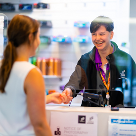 Customer Service Officer at Collingwood reception smiling at customer while serving them